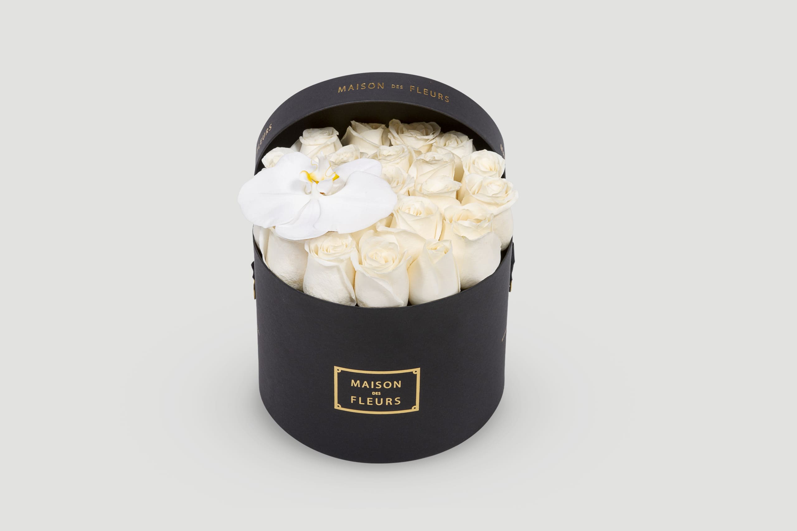 Black Round Hatbox Filled With White Roses and Topped With a White Orchid
